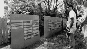 People reading names at a makeshift AIDS memorial.