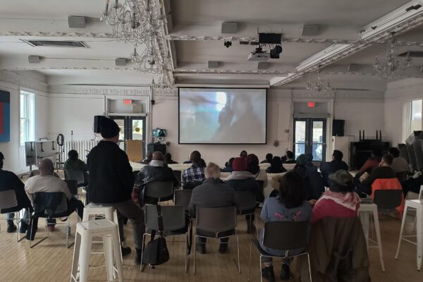 People gathered watching the sugarcane film