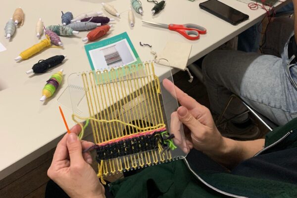 Someone holding their work from weaving workshop.